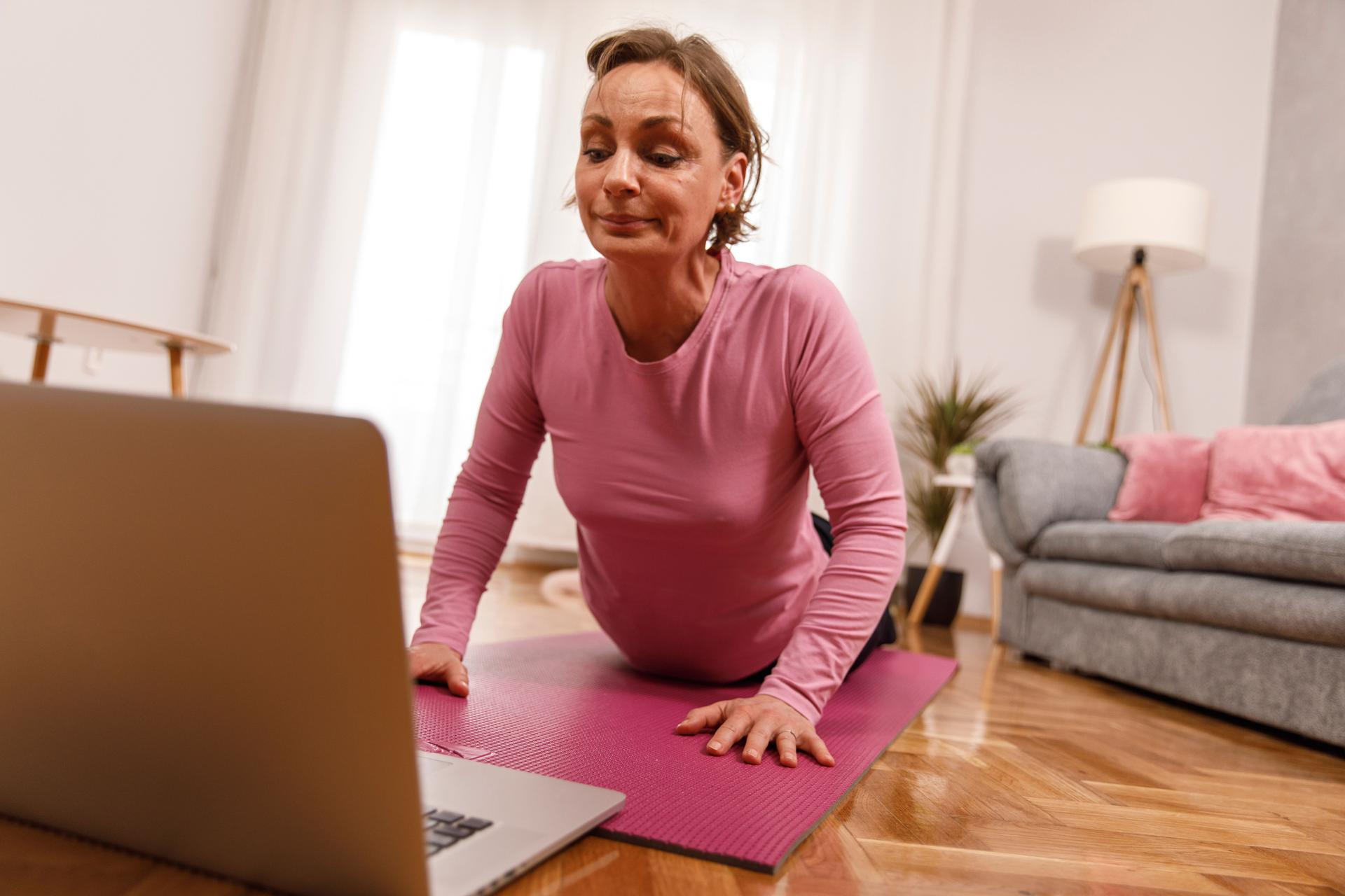 Woman doing a home workout while on a video call with personal trainer